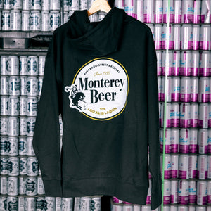 Black hoodie with 'Monterey Beer' logo hanging against a backdrop of beer cans.
