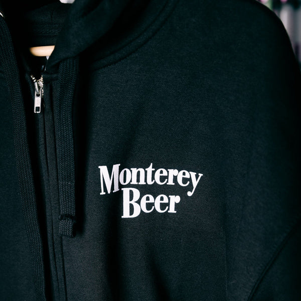 Black hoodie with 'Monterey Beer' text on a dark background